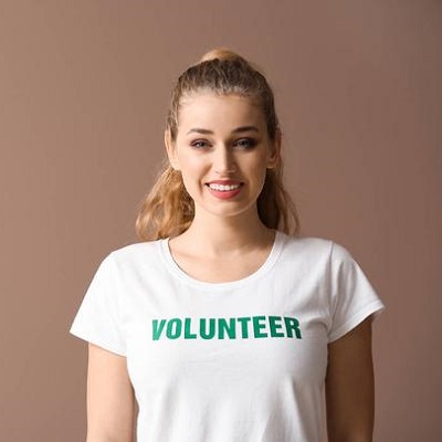 Young female volunteer on color background